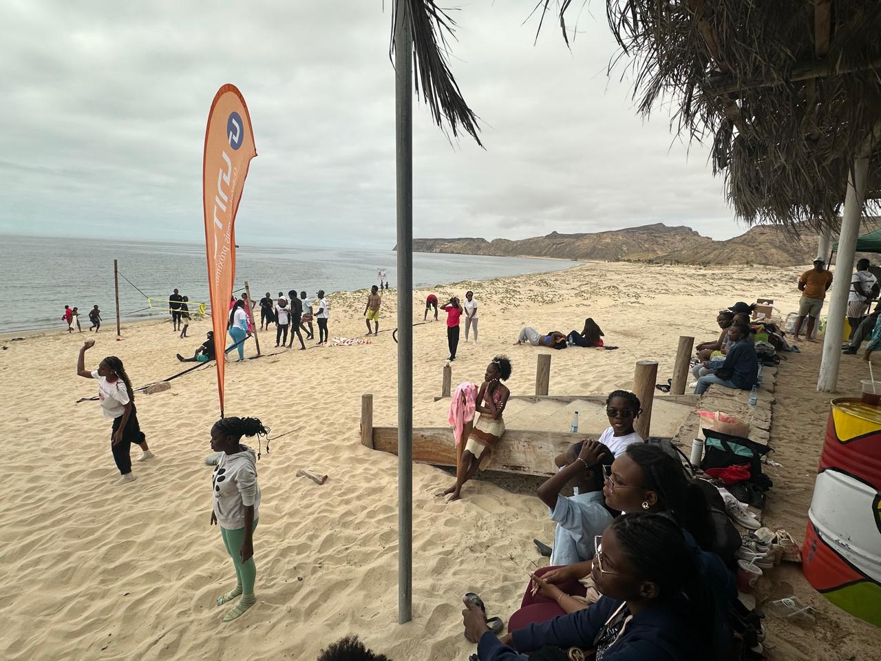 Jovens na praia junto a bandeira UNITEL durante o Festival
